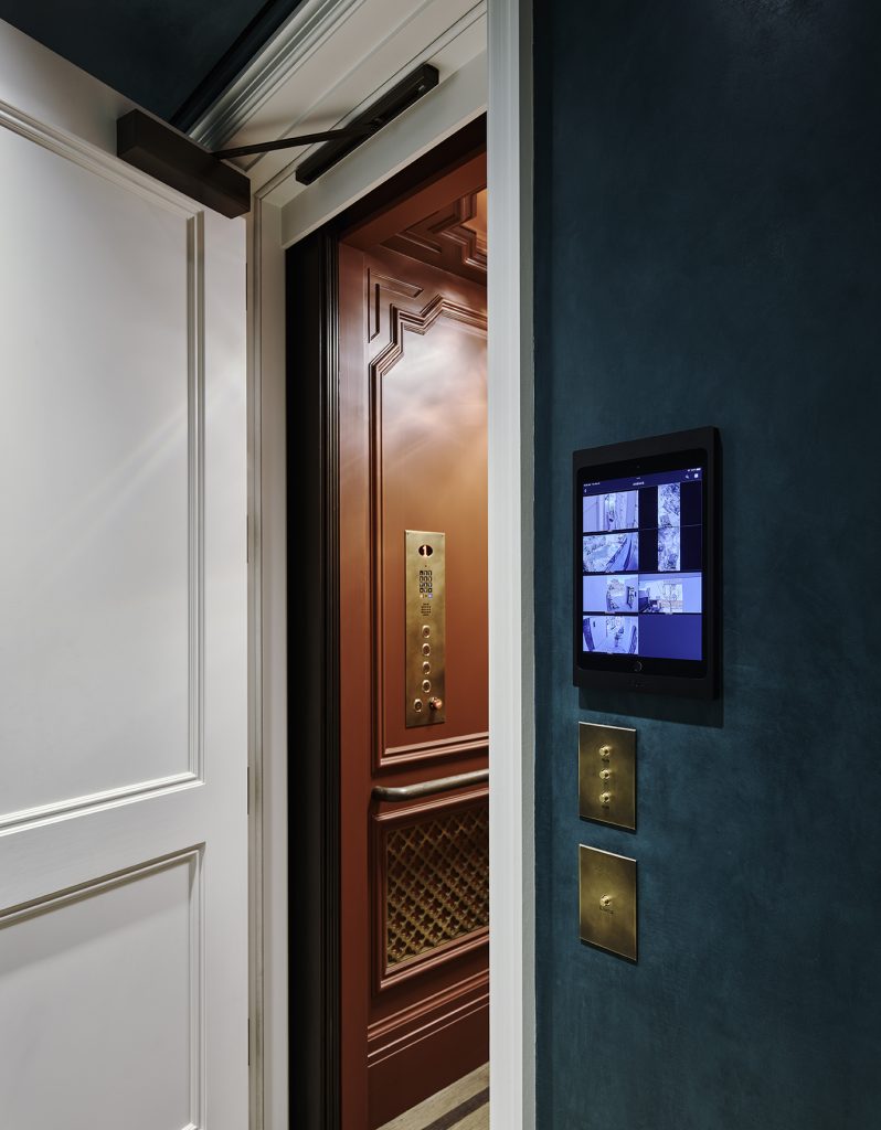 Wall-mounted security and home control touchscreen monitoring a luxury residence
