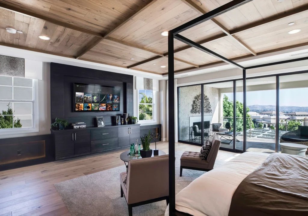 Luxury bedroom with integrated television, ceiling audio, lighting and expansive glazing