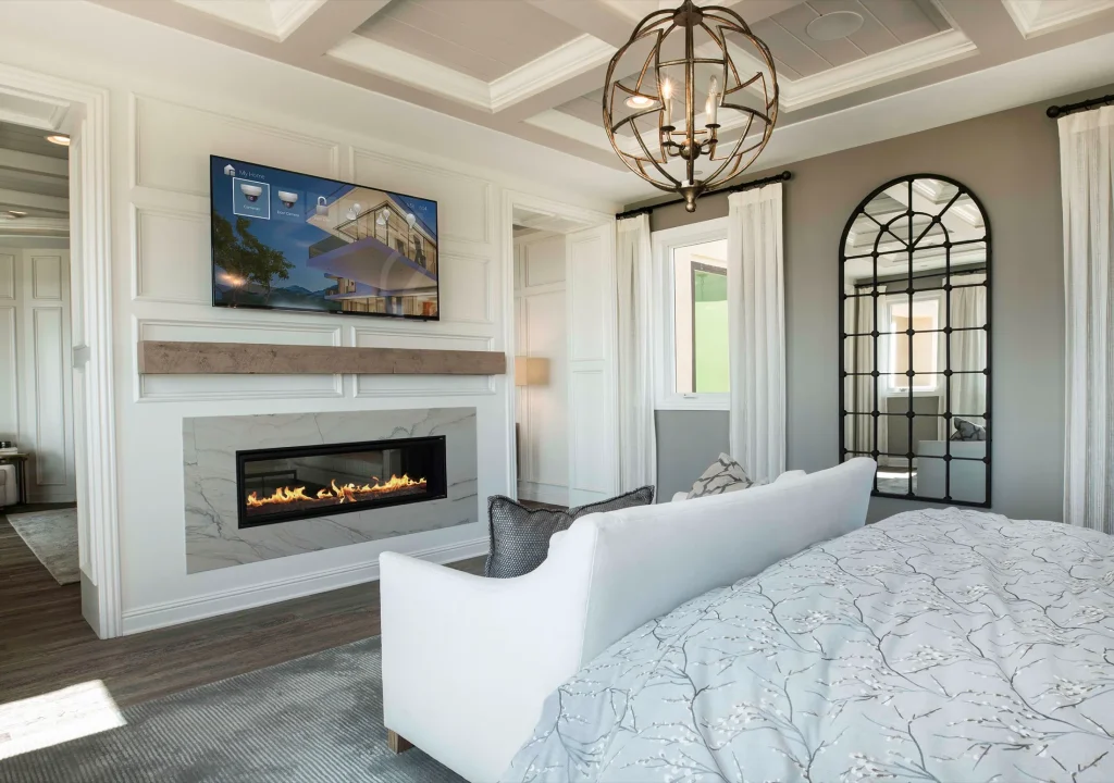 Elegant bedroom with integrated television, fireplace and home control