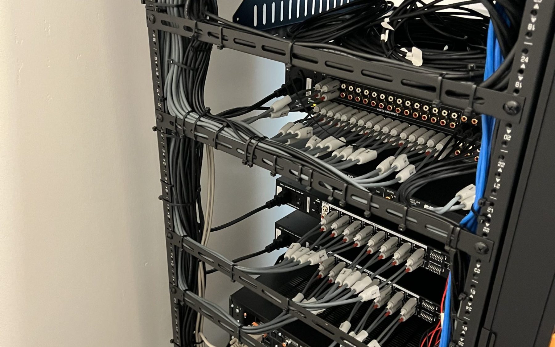 Central equipment rack with organized cabling and network infrastructure for a smart home