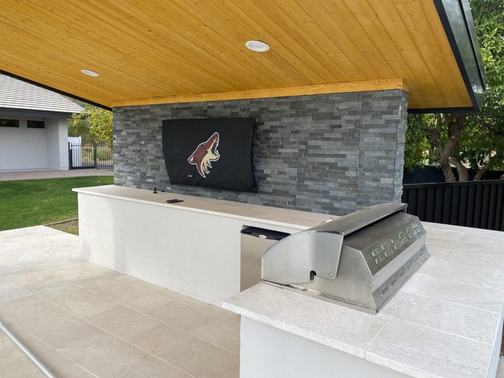 Outdoor television integrated into a covered living area