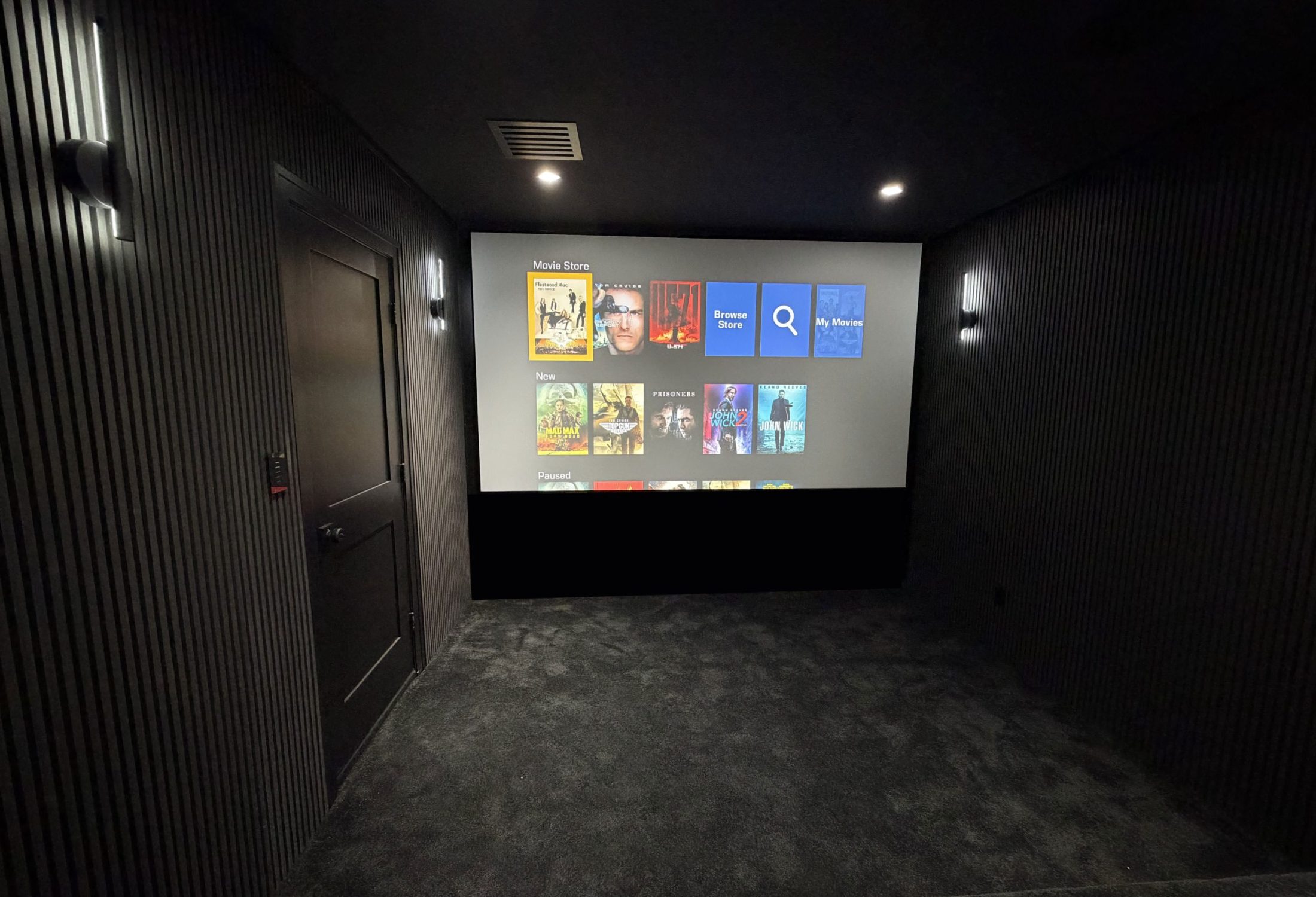 Dedicated home theater with immersive projection and visible surround speakers
