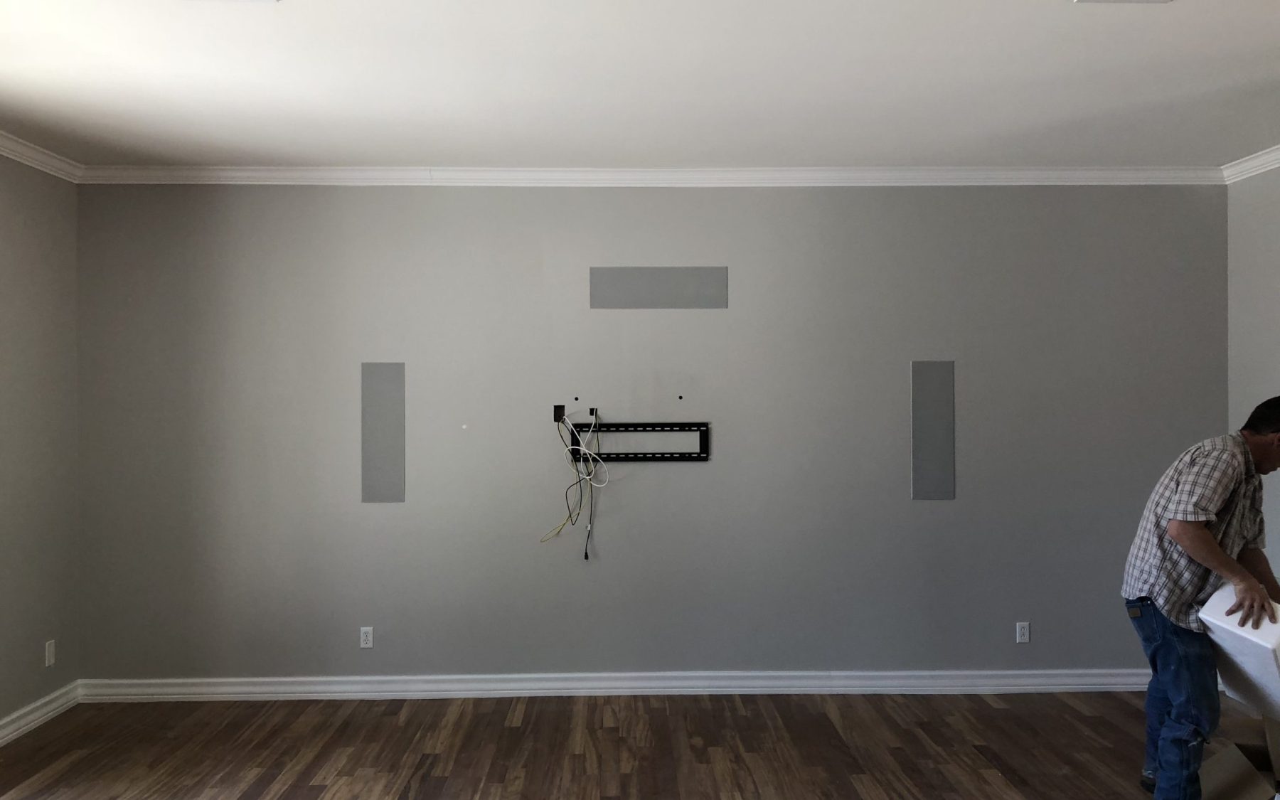 Media room during installation with a television mount, cable opening and front in-wall speaker locations